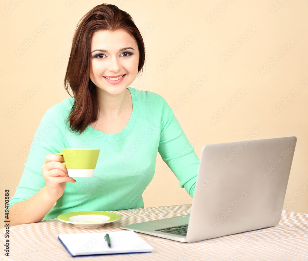 Beautiful young woman working on laptop on light background Beautiful young woman working on laptop on light background