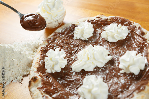 Italian Pizza, ingredients in the background on a wood table