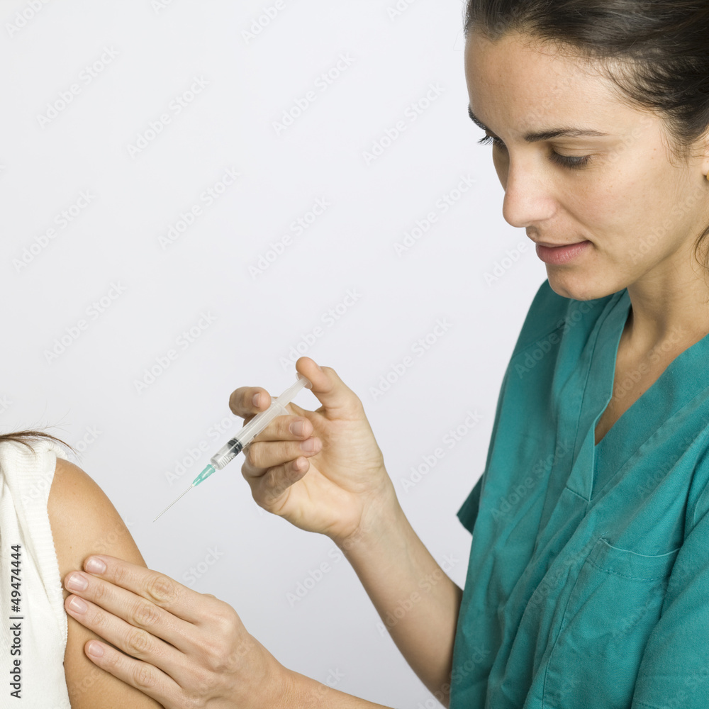 Junge Krankenschwester impft eine Patientin Junge Krankenschwester impft eine Patientin