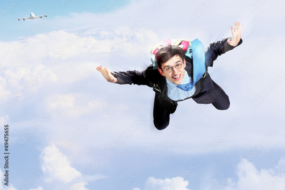 Young businessman flying with parachute on back Young businessman flying with parachute on back