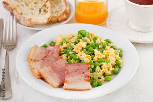 scrambled eggs, peas and bacon with bread and juice