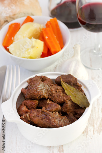 meat in the bowl with vegetables and red wine photo