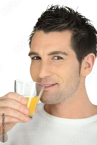 Man drinking glass of orange juice