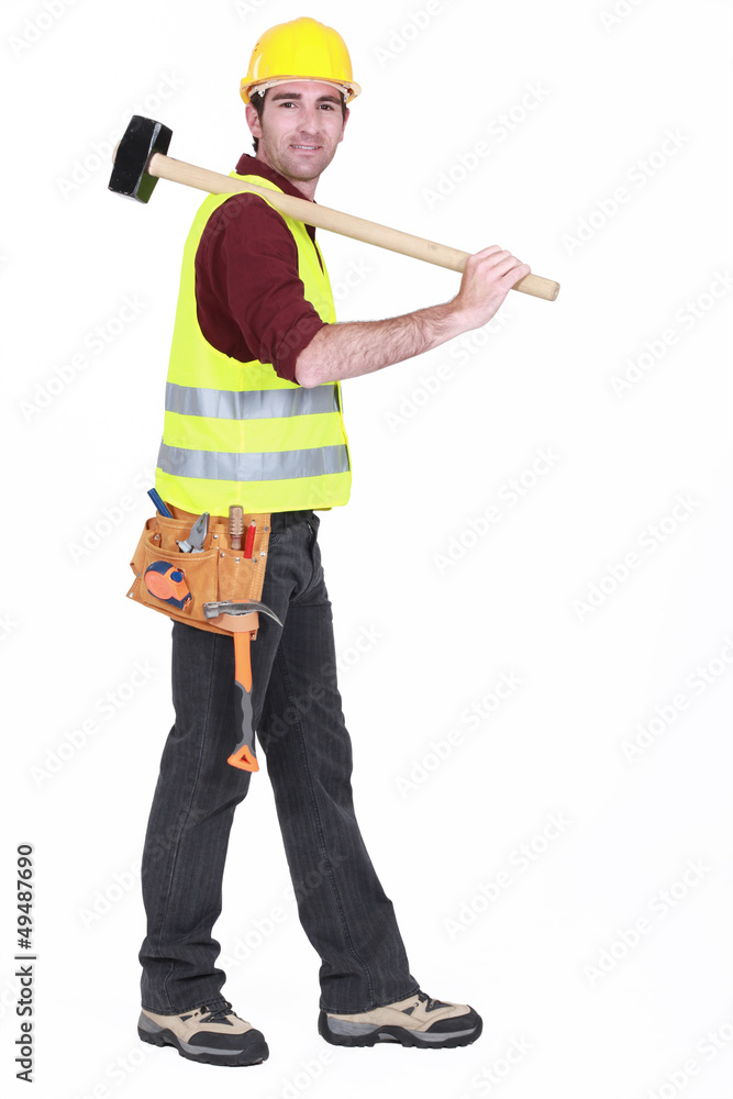 Worker carrying sledge-hammer over shoulder Worker carrying sledge-hammer over shoulder
