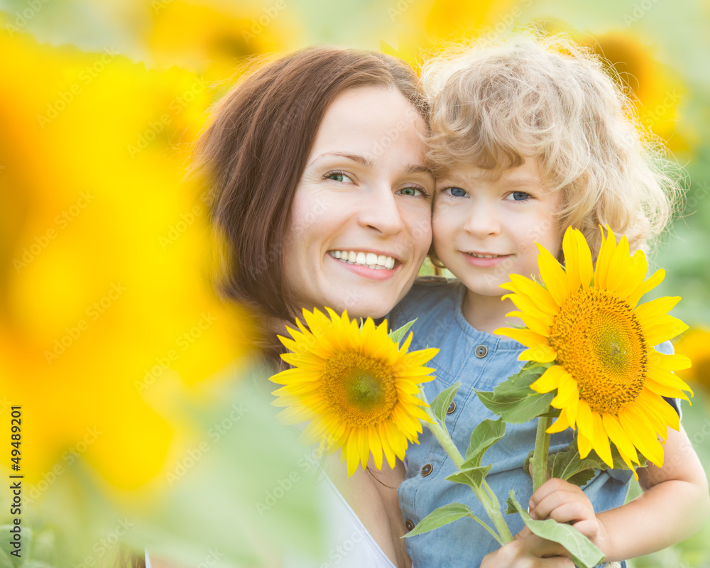 Happy family with beautiful sunflowers - obrazy, fototapety, plakaty 