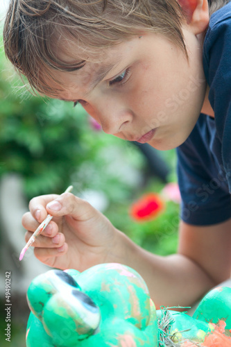 Boy painting with a brush