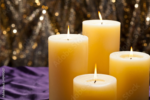 Four candles over purple velvet