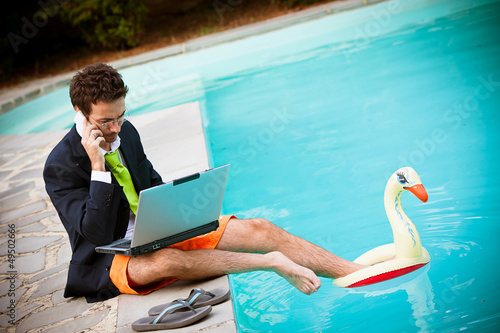 Funny Young Businessman with SwimmingTrunks next to the Pool