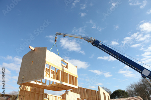 Crane lifting the framework of a house photo