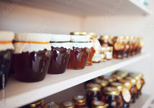 Shelf with home-made honey and jam photo
