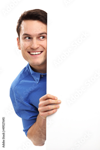 Man peeping over blank poster