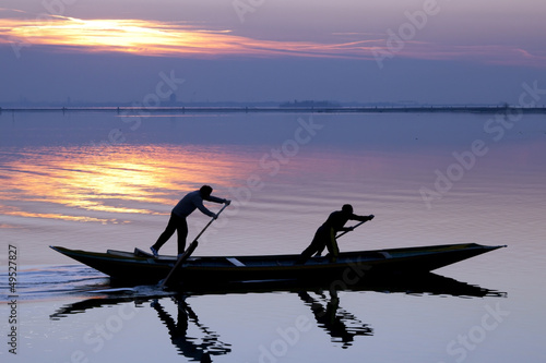 Foto Venice sunset silhouette of sinchronized rowing men