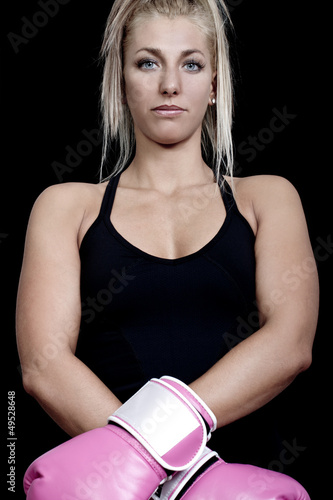 young woman wearing pink boxing gloves and ready to attac photo