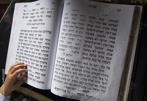 a boy's hand on a jewish bible