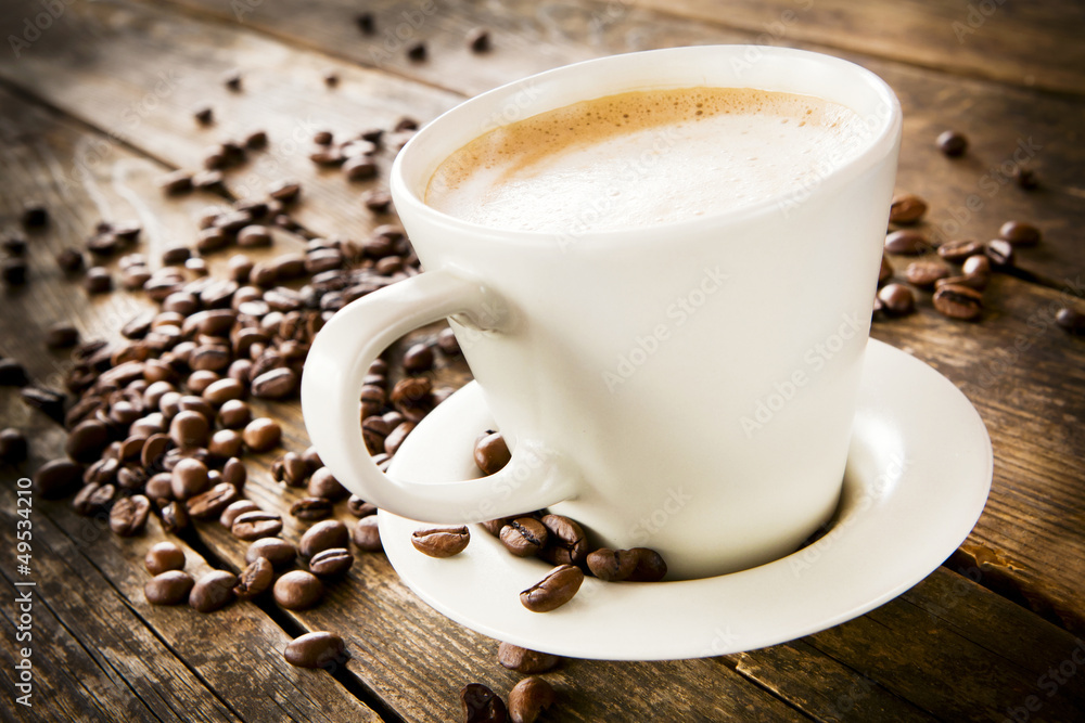 © Justinb - Cup of coffee and beans on wooden table.