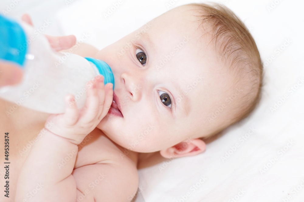 The five-months baby eats from a small bottle The five-months baby eats from a small bottle
