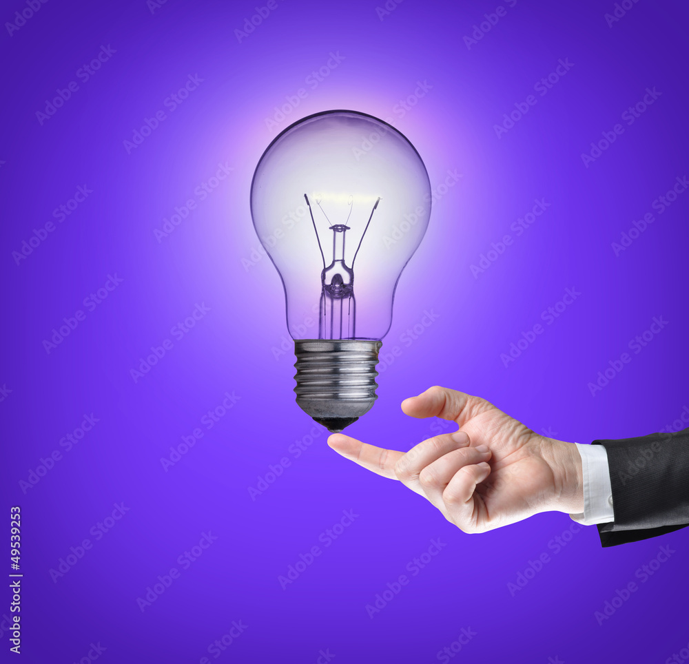Light bulb on tip of finger on businessman.Purple background. Light bulb on tip of finger on businessman.Purple background.