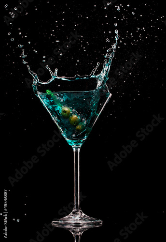 Martini drink with splash, isolated on black background