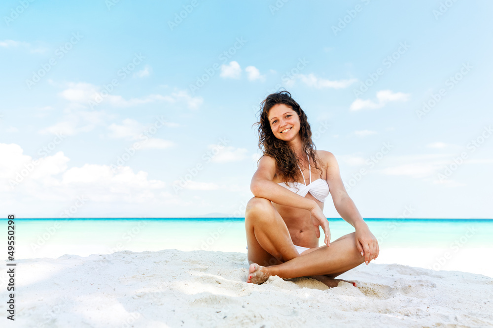 Portrait of a happy young woman posing while on the beach