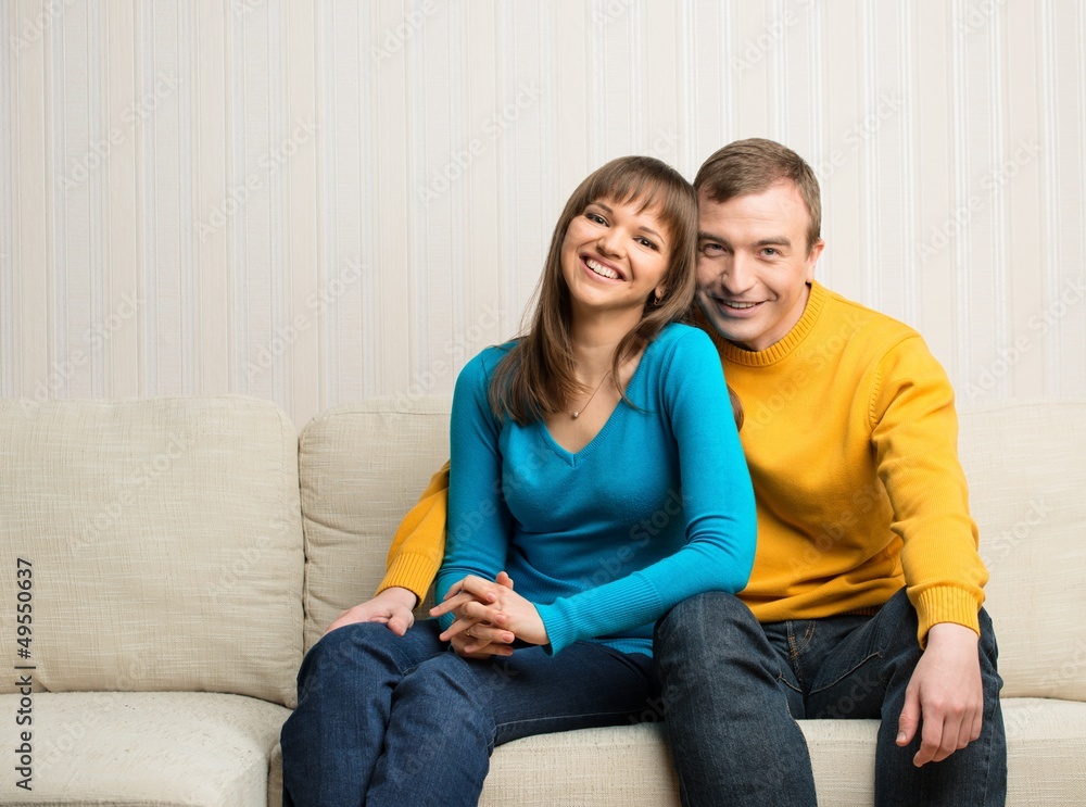 Happy couple sitting on sofa