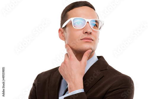 Young thoughtful businessman wearing glasses and holding chin on