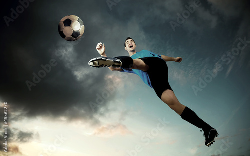football player on soccer field of stadium with drammatic sky