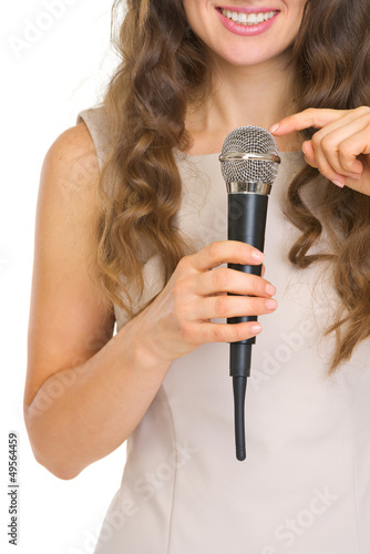 Closeup on young woman tapping on microphone to check sound