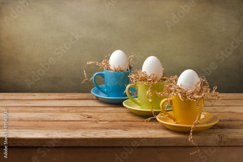 Canvas Print Background with easter eggs in coffee cups on wooden table