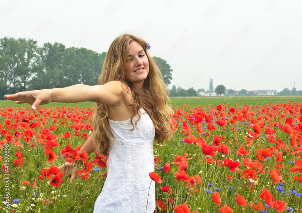 Den Sommer genießen / Junge Frau in Klatschmohnwiese