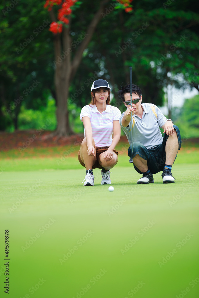 Obraz premium Professional teaching young woman golfer