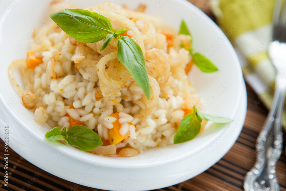 risotto with pumpkin and crispy onions in a white bowl risotto with pumpkin and crispy onions in a white bowl