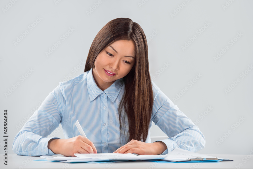 Closeup portrait of a cheerful young businesswoman with a pen in Closeup portrait of a cheerful young businesswoman with a pen in