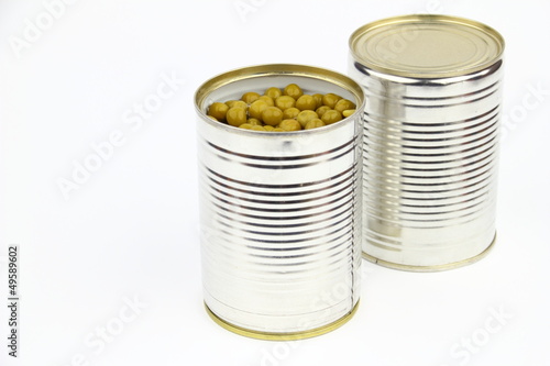 The tins with peas on the white background