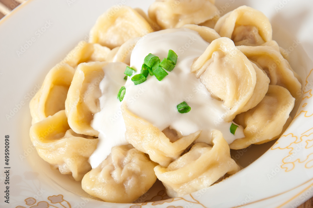 Russian national ravioli with sour cream on a plate Russian national ravioli with sour cream on a plate