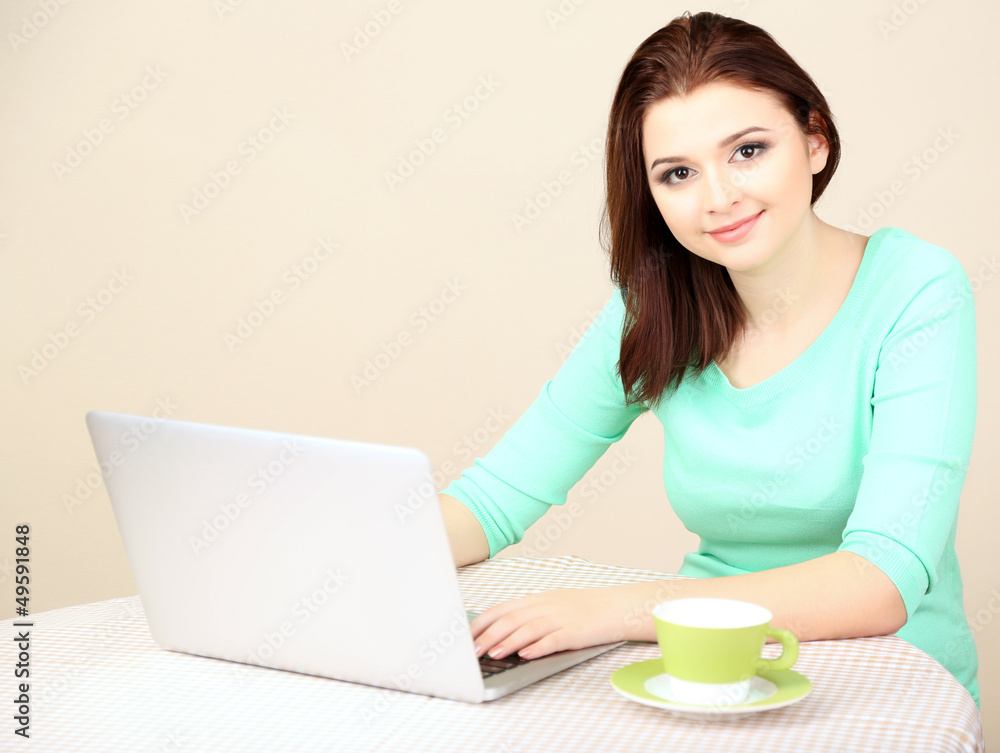 Beautiful young woman working on laptop on light background Beautiful young woman working on laptop on light background