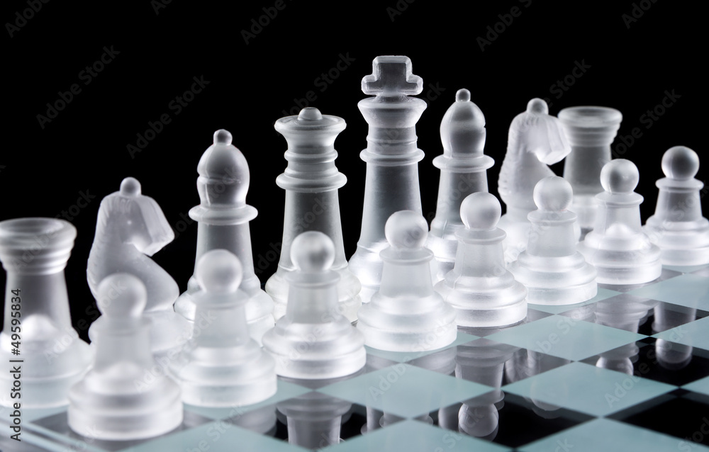 Set of white glass chess pieces over black background