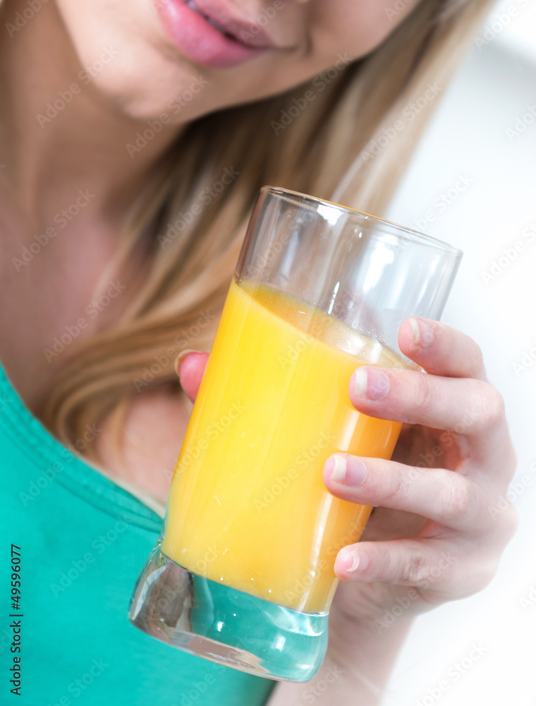 Attractive girl drinking an orange in a kitchen Attractive girl drinking an orange in a kitchen