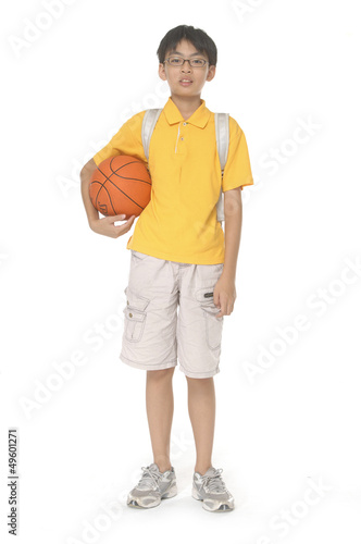 Full length portrait of a child with backpack holding a ball