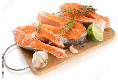 Raw trout steaks on cutting board isolated on white
