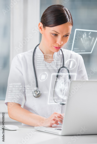 Pretty female medicine doctor working with modern computer inter photo