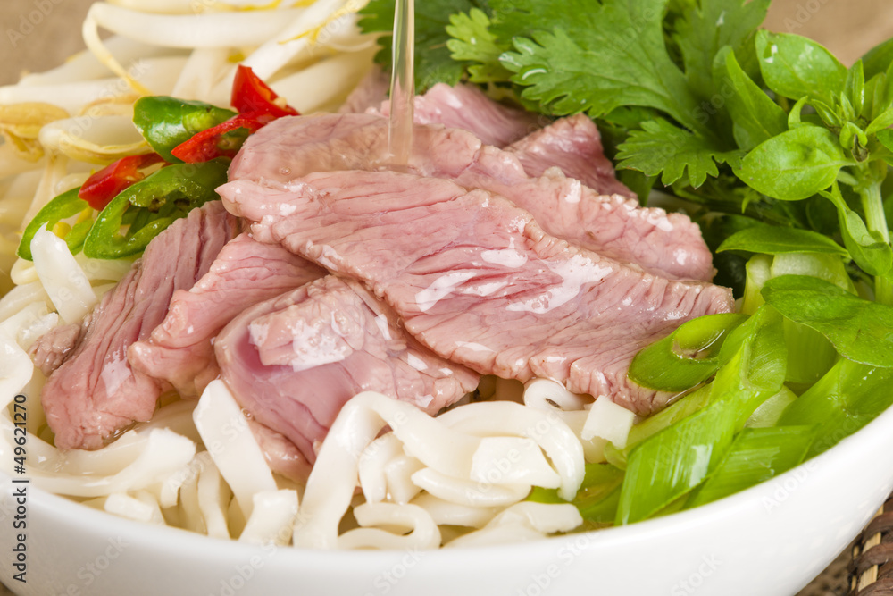 Pho Bo - Vietnamese rice noodle soup with beef, herbs and chili