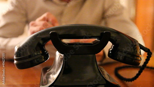 Vintage black telephone. Man dials 