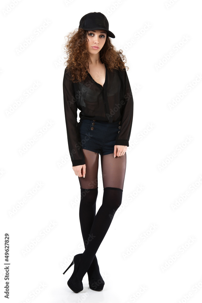 Attractive curly girl in black shorts and a baseball cap posing. Attractive curly girl in black shorts and a baseball cap posing.
