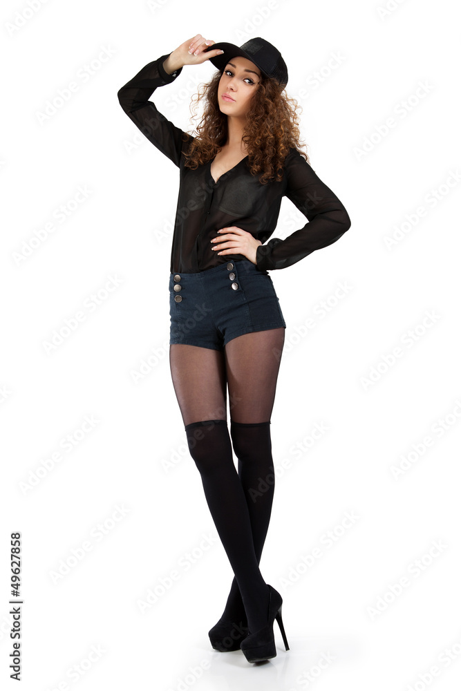 Attractive curly girl in black shorts and a baseball cap posing Attractive curly girl in black shorts and a baseball cap posing