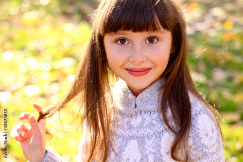Portrait of little girl in the autumn park outdoors