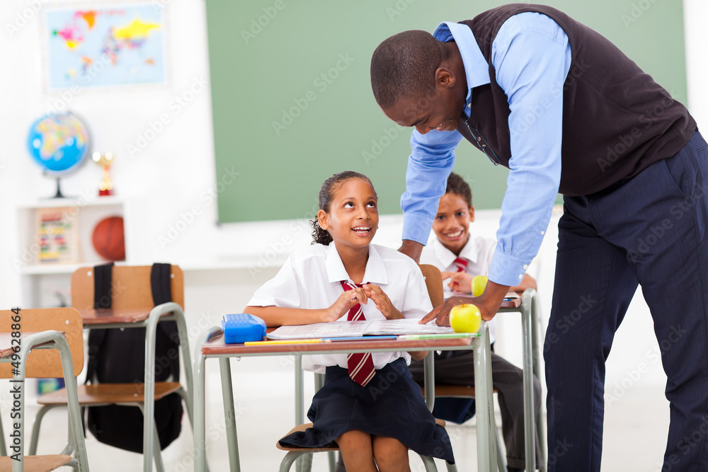 elementary teacher helping student in classroom elementary teacher helping student in classroom