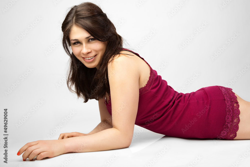 Beautiful woman in the red jersey sits on the floor. Beautiful woman in the red jersey sits on the floor.