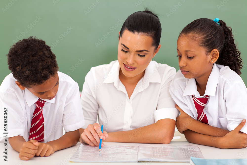 pretty elementary school teacher helping students in classroom pretty elementary school teacher helping students in classroom