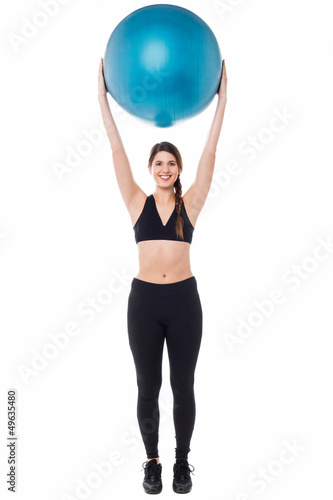 Fitness enthusiast holding ball above her head