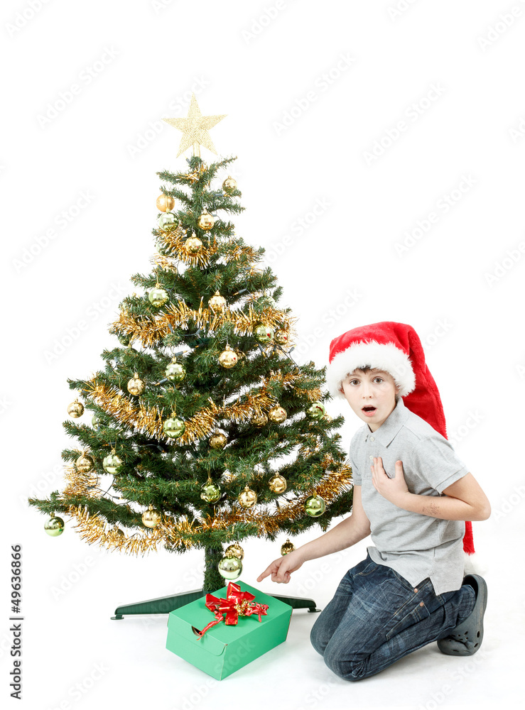 happy boy in santa hat surprised by christmas present happy boy in santa hat surprised by christmas present